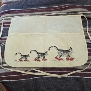 Vintage white apron features the iconic "Cat with Sneakers" illustration